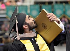 International student kissing graduate diploma